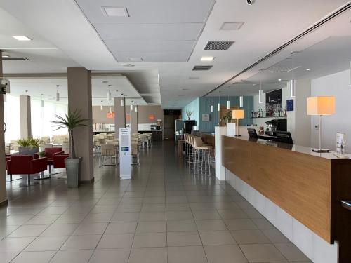 a restaurant with a bar and tables and chairs at Holiday Inn Express Vitoria by IHG in Vitoria-Gasteiz
