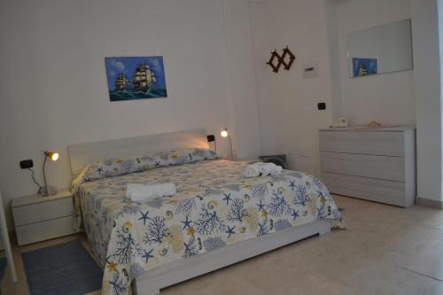 una camera con un letto con copriletto blu e bianco di Casa Vacanze La Vela a Murta Maria