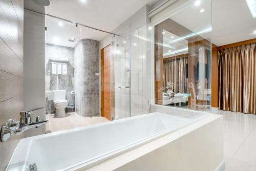 a white bathroom with a tub and a shower at 247 Boutique Hotel in Pattaya Central