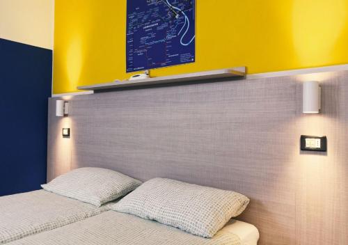 a bed with two pillows on top of it at Hotel Elba in Rimini