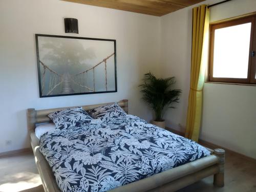 瓦勒羅蓋的住宿－Pura Vida，卧室配有一张床铺,墙上挂着桥画