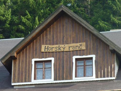 a sign on the top of a building with two windows at Horský Ranč in Pec pod Sněžkou