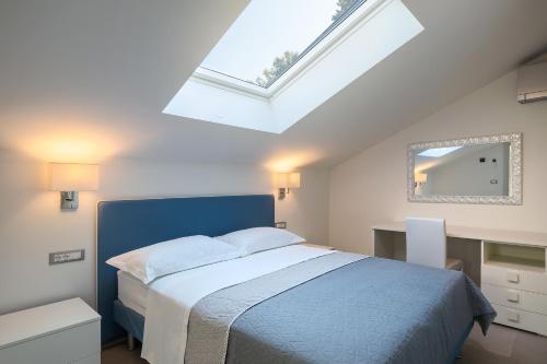 a bedroom with a blue bed and a skylight at Apartmani Mare verde in Novigrad Istria