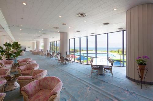 a lobby with chairs and tables and a pool at Hotel Izukyu in Shimoda
