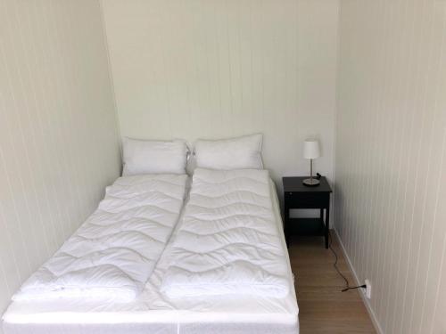 un letto bianco in una stanza con tavolino di Saltvold leilighet nr1 a Røldal