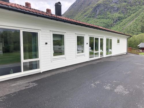 a white building with large windows and a mountain at Saltvold leilighet nr1 in Røldal