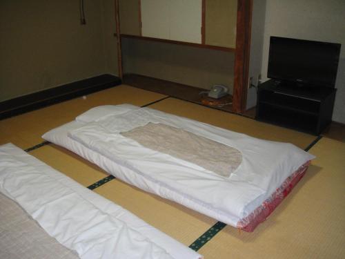 ein Bett auf dem Boden in einem Zimmer in der Unterkunft Matsuichi in Hamamatsu