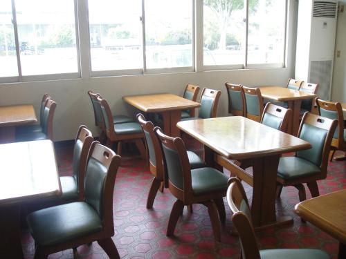 a dining room with tables and chairs and windows at Matsuichi in Hamamatsu