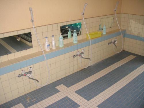 a bathroom with two shower faucets and a mirror at Matsuichi in Hamamatsu