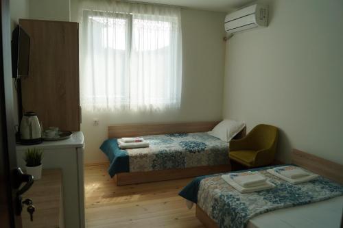 a small bedroom with two beds and a window at Guest House Di Mare in Obzor