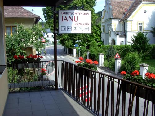 un balcone con un cartello per un cortile fiorito di Frühstückspension Leopold Janu a Senftenberg