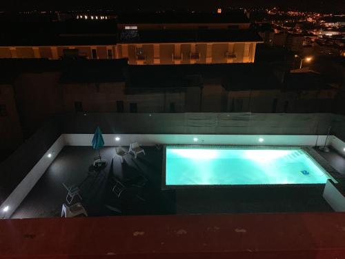 una vista panoramica su una piscina di notte di Casa dos Carvalhos a Coimbra