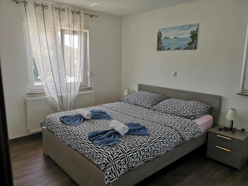 a bedroom with a bed with blue bows on it at Apartmani Manda in Omišalj