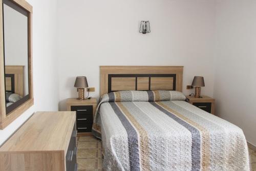a bedroom with a bed and two tables with lamps at Apartamentos Las Americas - Blanes Beach in Blanes