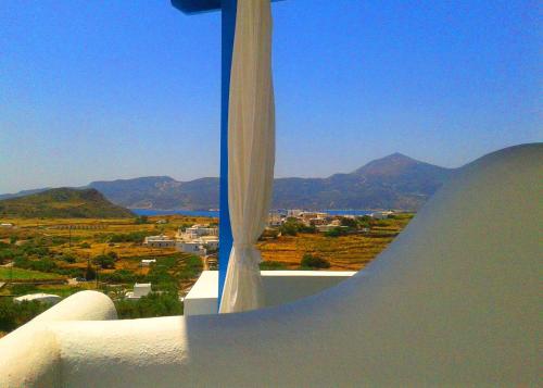 a window with a view of a valley and mountains at Georgia Rooms Milos in Plaka Milou