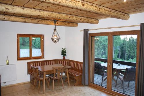 une salle à manger avec une table et un balcon dans l'établissement Blockhütte Radmer, à Radmer an der Hasel