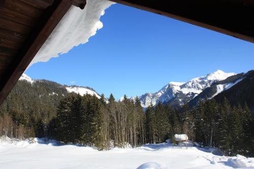 a view of the mountains from a cabin in the snow at Blockhütte Radmer in Radmer an der Hasel