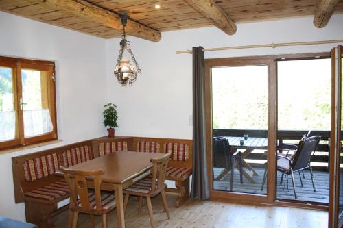 a dining room with a table and chairs and a patio at Blockhütte Radmer in Radmer an der Hasel