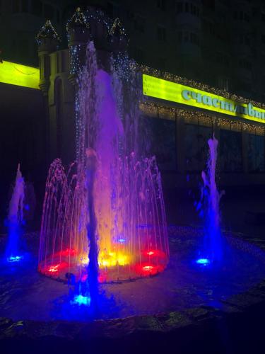 a fountain with colored lights in front of a building at Strada 25 Octombrie in Tiraspol