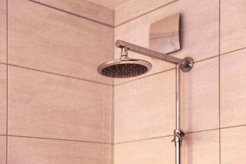 a shower with a shower head in a bathroom at bestprice Hotel Eschweiler in Eschweiler