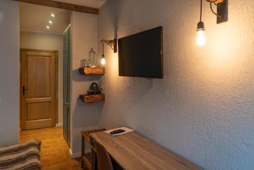 a living room with a tv on a wall at Pensiunea Belvedere in Tîrgu Neamţ