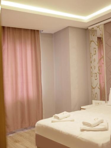 two beds in a room with a pink curtain at The Zanadu İstanbul in Istanbul