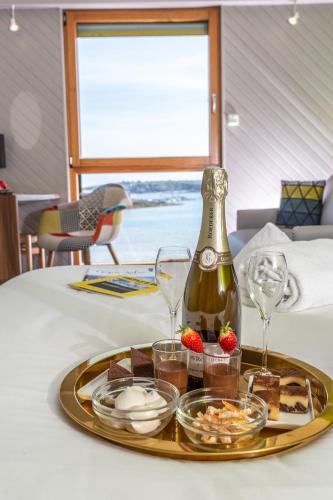 - un plateau de nourriture sur une table avec une bouteille de vin dans l'établissement Logis Hôtel de France - Face à la Mer, à Camaret-sur-Mer