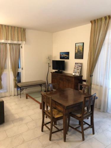 a living room with a wooden table and a television at Casa Vacanza La Luna in Sarzana