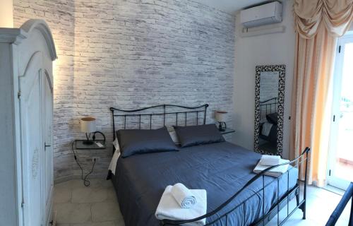 a bedroom with a bed and a brick wall at Casa Vacanza La Luna in Sarzana