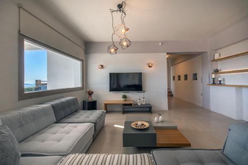 a living room with a couch and a tv at Heaven's Hill in Naxos Chora