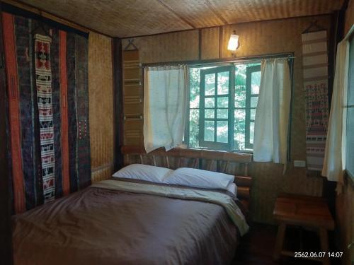 Habitación pequeña con cama y ventana en Baan Suan Jantra Home Stay, en Chiang Rai