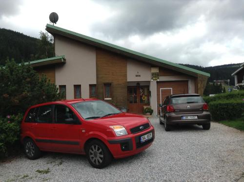 two cars parked in a parking lot in front of a building at Ubytování Zmatlíková in Pec pod Sněžkou