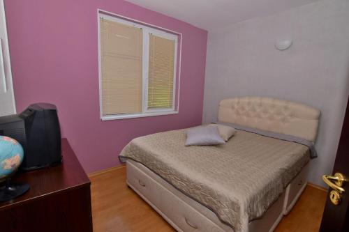 ein kleines Schlafzimmer mit einem Bett und einem Fenster in der Unterkunft апартамент за гости Георгиеви in Weliko Tarnowo