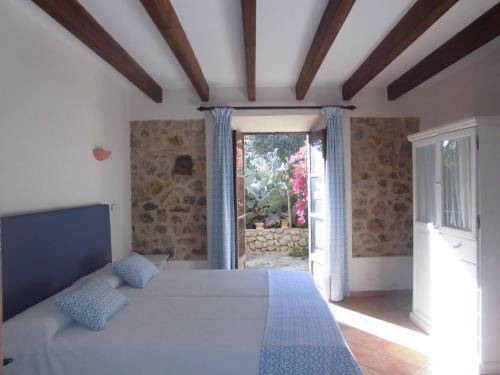 a bedroom with a large bed and a window at Agroturismo Na Set Centes - Adults Only in Artá