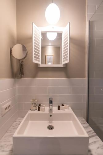 a bathroom with a white sink and a mirror at Pensiunea Belvedere in Tîrgu Neamţ