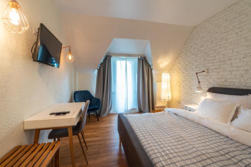 a hotel room with a bed and a desk at Pensiunea Belvedere in Tîrgu Neamţ