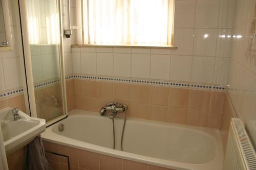 a bathroom with a bath tub and a sink at Les Gîtes d'Olloy - Le Roi Cerf in Olloy-sur-Viroin