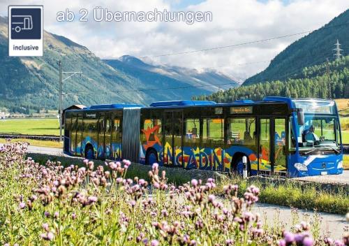 a bus driving down a road next to a field at Hotel Garni Chesa Mulin in Pontresina
