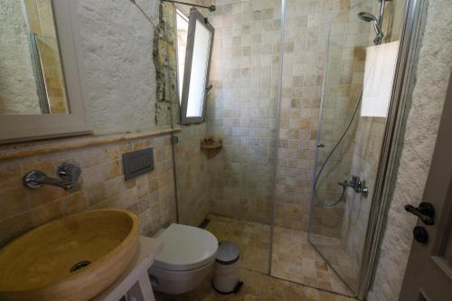 a bathroom with a toilet and a sink and a shower at Çona Butik Otel in Alacati