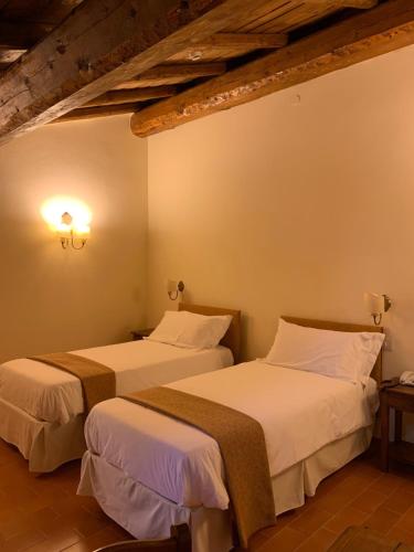 two beds in a hotel room with twoermottermott at PALAZZO DE' ROSSI HOTEL in Sasso Marconi