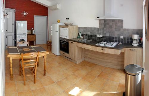 a kitchen with a counter and a table in it at Gîte Domaine Le Fragnaud in Saint-Porchaire