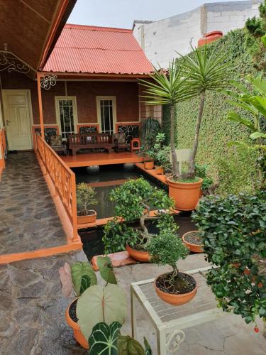a patio with potted plants and a house at Villa Daffa Ciwidey in Ciwidey