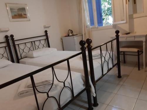 
a hotel room with two beds and two lamps at Pergola Hotel in Agios Nikolaos
