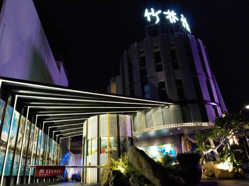 un bâtiment avec des lumières au-dessus de celui-ci la nuit dans l'établissement Refinement Motel, à Taichung