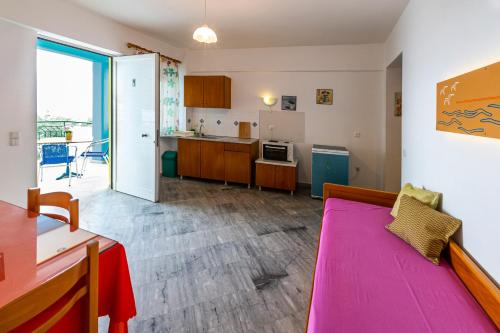 チラニにあるIris Apartmentsのリビングルーム(ピンクのソファ付)、キッチンが備わります。