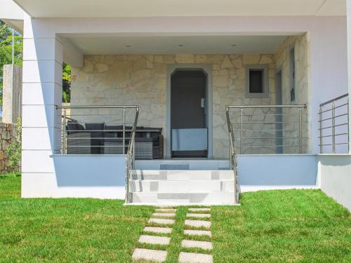 a house with a staircase in the grass at Anemos Luxury Apartments in Ayios Nikolaos Sithonia