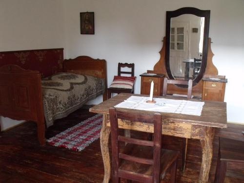a room with a table and a bed and a mirror at Erdősmecskei sváb vendégházak és Jurtaszállás in Erdősmecske