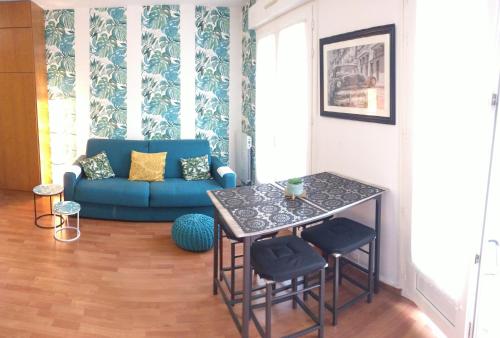 un salon avec un canapé bleu et une table dans l'établissement Studio Royal by Beds4Wanderlust - Place du marché avec parking privé, à Fontainebleau