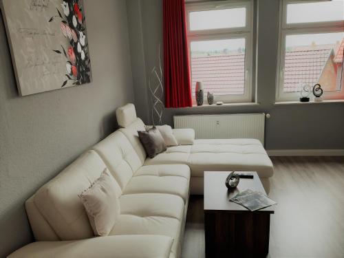 a living room with two white couches and a table at Hotel Fabrice in Bad Klosterlausnitz