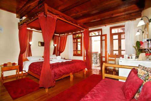a bedroom with a canopy bed with red curtains at Palazzo di Pietro in Chania